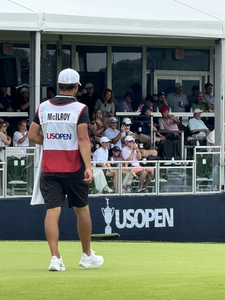 The caddie for Rory McIlroy is seen in front of the grandstands at the US Open